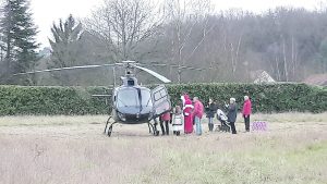 Pascal Windels du Comité invite les enfants qui ont gagné à la tombola à monter en hélicoptère avec le Père Noël.