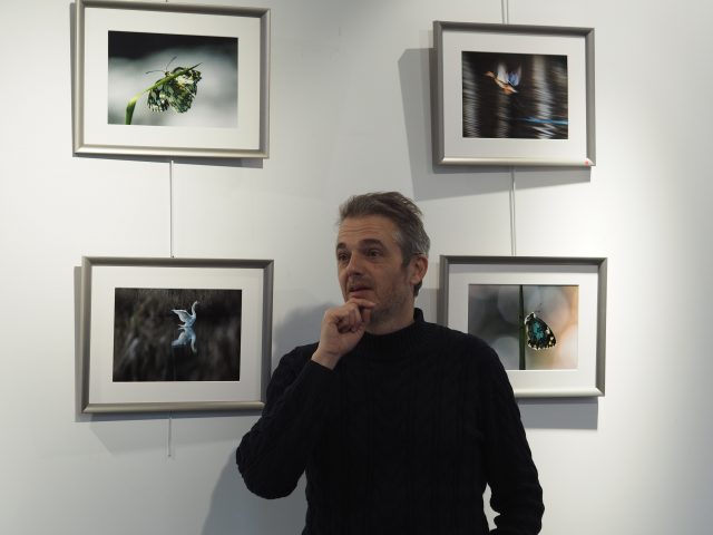 Bruno Grelet devant quatre de ses photographies.