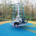 Le tourniquet Twitster de la marque Kompan est inclusif : les personnes en fauteuil roulant peuvent s’installer sur le disque et se tenir aux cordes.